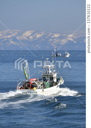Photographing a fishing boat leaving Ochibe Fishing Port in Yakumo Town, Hokkaido in early spring 137610122