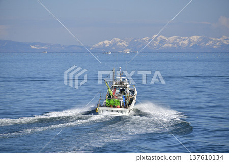 Photographing a fishing boat leaving Ochibe Fishing Port in Yakumo Town, Hokkaido in early spring Photographing a fishing boat leaving Ochibe Fishing Port in Yakumo Town, Hokkaido in early spring 137610134