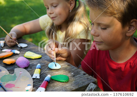Simple stones become playful art through children's vibrant acrylics, crafted into memorable DIY gifts. Simple stones become playful art through children's vibrant acrylics, crafted into memorable DIY gifts. 137610692