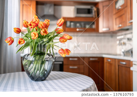 Tulips bouquet in white vase on kitchen table interior 137610793