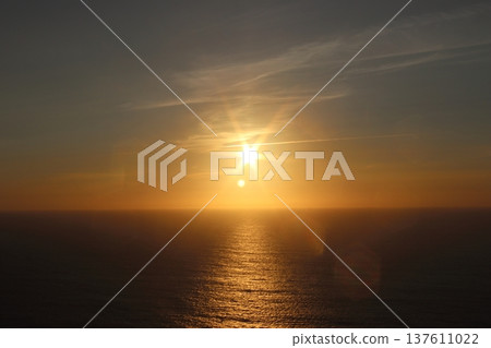 Golden Sunset Over the Atlantic Ocean with Sunstar Flare and Calm Water 137611022