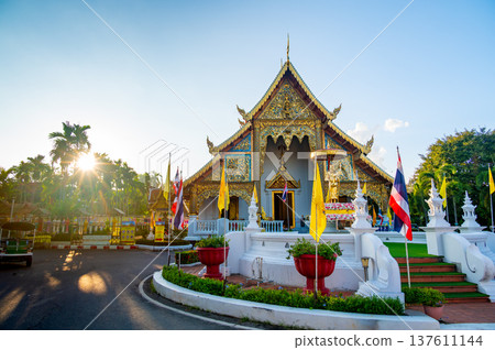 Exterior view of Wat Phra Singh Woramahawihan temple in Chiang Mai Thailand at sunset. Historic Buddhist architecture bathed in warm light, highlighting cultural heritage and serene atmosphere. Exterior view of Wat Phra Singh Woramahawihan temple in Chiang Mai Thailand at sunset. Historic Buddhist architecture bathed in warm light, highlighting cultural heritage and serene atmosphere. 137611144