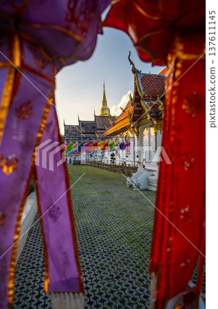 Exterior view of Wat Phra Singh Woramahawihan temple in Chiang Mai Thailand at sunset. Historic Buddhist architecture bathed in warm light, highlighting cultural heritage and serene atmosphere. Exterior view of Wat Phra Singh Woramahawihan temple in Chiang Mai Thailand at sunset. Historic Buddhist architecture bathed in warm light, highlighting cultural heritage and serene atmosphere. 137611145