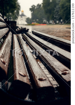 Wet Wooden Bench After Rain in City Park 137611199