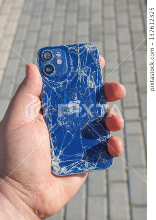 broken Apple iPhone in hand on the background of the sidewalk broken Apple iPhone in hand on the background of the sidewalk 137612325