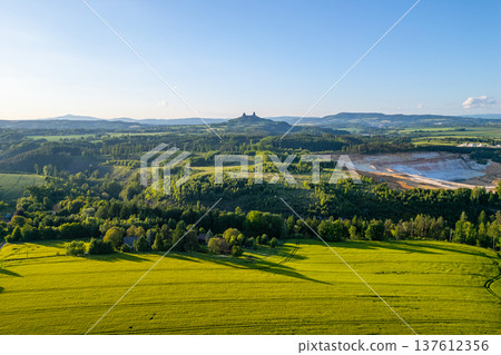 The countryside of Bohemian Paradise in Czechia during summer. Trosky Castle stands on a hill overlooking the green fields and forests. 137612356