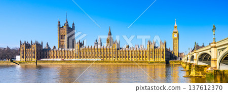 The Houses of Parliament and Big Ben along the River Thames. The sky is clear. People visit the area to admire this famous landmark. The Houses of Parliament and Big Ben along the River Thames. The sky is clear. People visit the area to admire this famous landmark. 137612370