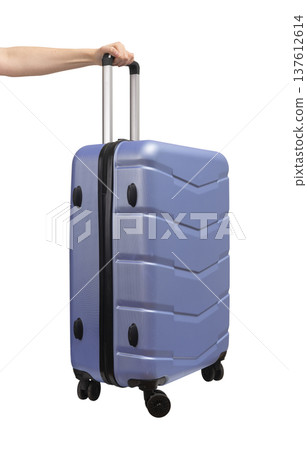 Hand holding suitcase. Four-wheeled carry-on with telescopic handle, side tilt and hard Hand holding suitcase. Four-wheeled carry-on with telescopic handle, side tilt and hard 137612614