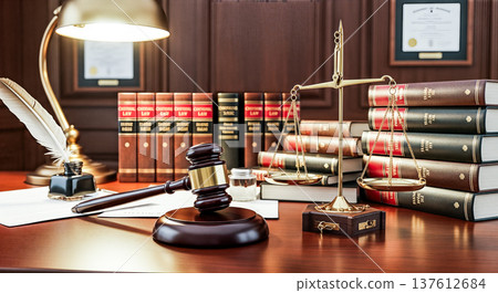 Wooden judge gavel golden scales of justice near stack of law books on lawyer desk inside courtroom representing legal system jurisprudence attorney practice 137612684