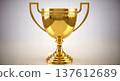 Shiny golden champion cup trophy with elegant handles standing isolated on bright white background symbolizing sport competition victory first place business achievement 137612689