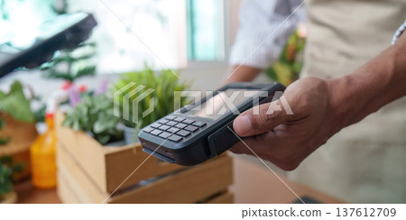 Sustainability in Action: Eco-friendly payment processing in a plant shop Sustainability in Action: Eco-friendly payment processing in a plant shop 137612709