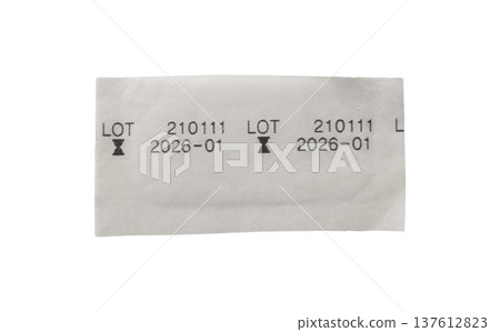 Paper label fragment with printed lot number and expiration date, batch identification. packaging 137612823