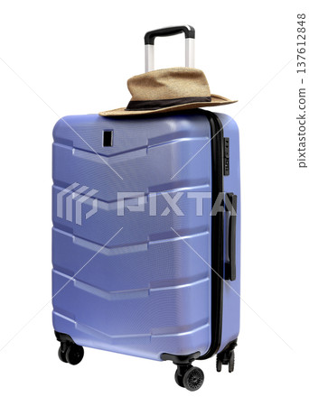 Wheeled suitcase, baggage with summer hat on top. Brimmed sunhat on large hardshell carry on luggage 137612848