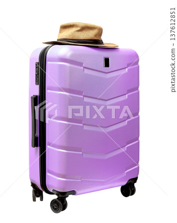Wheeled hardcase pink suitcase with sunhat on top. Tilted perspective, travel gear. Closed carry on 137612851