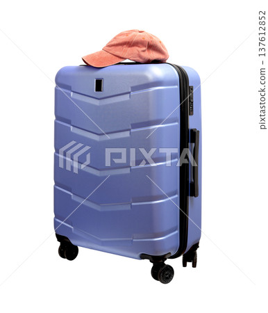 Angled view of a polycarbonate wheeled suitcase. Pink baseball cap on top of hardshell luggage, Angled view of a polycarbonate wheeled suitcase. Pink baseball cap on top of hardshell luggage, 137612852