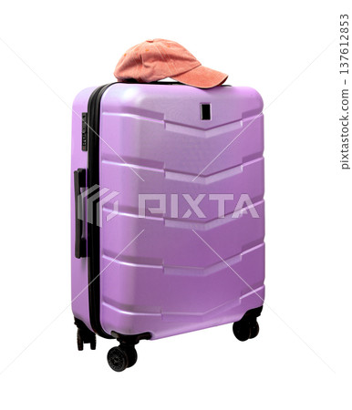 Giant wheeled suitcase with pink baseball cap on top. Hard polycarbonate shell shown at a tilted Giant wheeled suitcase with pink baseball cap on top. Hard polycarbonate shell shown at a tilted 137612853
