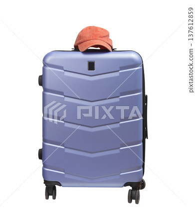 Front view close up of a giant wheeled suitcase with pink baseball cap on top. Modern polycarbonate Front view close up of a giant wheeled suitcase with pink baseball cap on top. Modern polycarbonate 137612859