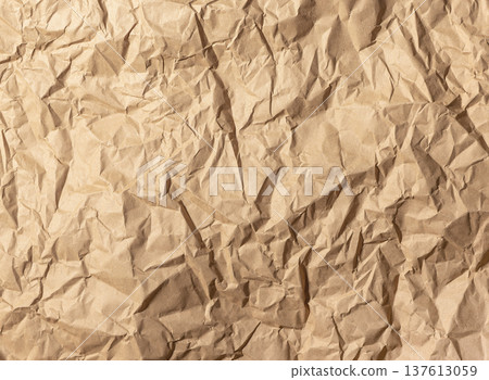 Crumpled brown kraft paper texture background. Wrinkled packaging sheet full frame composition. Rustic craft material backdrop concept.. Crumpled brown kraft paper texture background. Wrinkled packaging sheet full frame composition. Rustic craft material backdrop concept.. 137613059