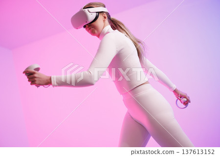 Woman in VR glasses against neon background 137613152