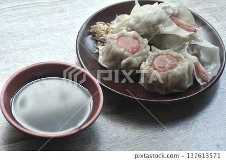 steamed Chinese dumpling stuffing shrimp and chop pork with salty egg on plate dipping soy sauce 137613571