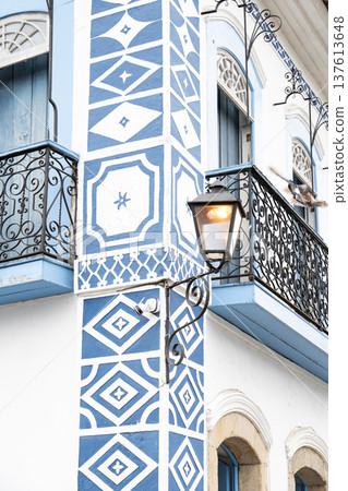 Blue and white geometric colonial facade with vintage street lamp Blue and white geometric colonial facade with vintage street lamp 137613648