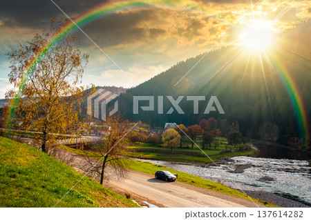 sunset over mountain landscape during fall season. rural scenery with river. picture of a countryside road through valley near village for travel background. weather with rainbow sunset over mountain landscape during fall season. rural scenery with river. picture of a countryside road through valley near village for travel background. weather with rainbow 137614282