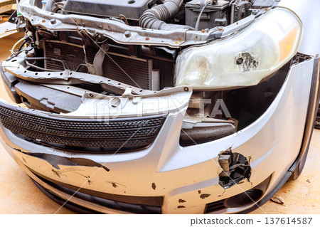Car with damaged front showing signs of an accident in garage 137614587