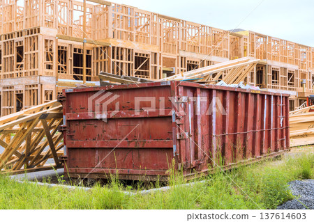 Construction site red dumpster with building materials wooden frames 137614603