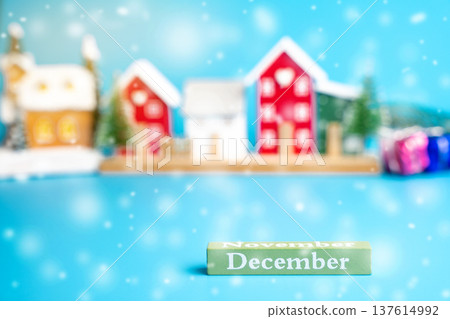December block against the background of a Christmas tree and a houses with snow. Concept of the beginning of a new winter month December block against the background of a Christmas tree and a houses with snow. Concept of the beginning of a new winter month 137614992