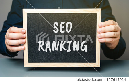 Board with words SEO ranking. Position a website or webpage holds in the search engine results pages (SERPs) for a specific keyword or phrase. Concept of internet and technology Board with words SEO ranking. Position a website or webpage holds in the search engine results pages (SERPs) for a specific keyword or phrase. Concept of internet and technology 137615024