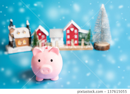 Piggy bank, Christmas tree and houses. Winter budget for the Christmas holidays budget. New Year or Xmas winter holiday. Snow, snowfall Piggy bank, Christmas tree and houses. Winter budget for the Christmas holidays budget. New Year or Xmas winter holiday. Snow, snowfall 137615055