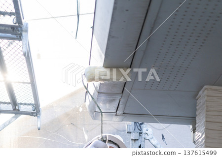 工匠正在用滾筒粉刷房屋外牆的屋簷。 137615499