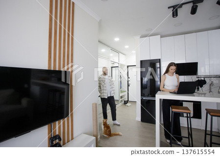 Cute woman with laptop and her hasband and cat pet at home 137615554