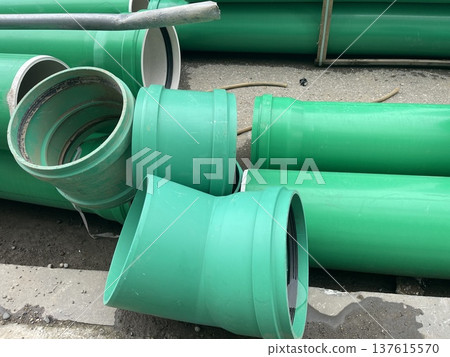 Green pipes stacked on a construction site during daytime near the urban area 137615570