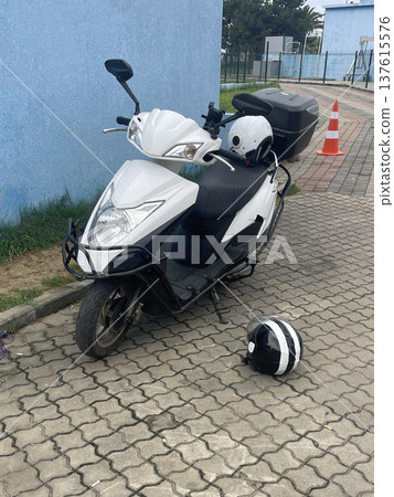 Motorcycle parked by the road with a helmet nearby at a school area during the daytime Motorcycle parked by the road with a helmet nearby at a school area during the daytime 137615576
