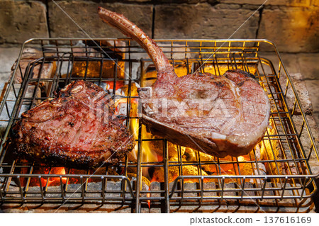 Tomahawk and T-bone steaks grilling top view Tomahawk and T-bone steaks grilling top view 137616169