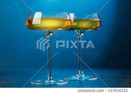 Champagne glasses on dark blue background Champagne glasses on dark blue background 137616182