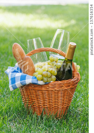 Picnic basket with wine, grapes, and baguette Picnic basket with wine, grapes, and baguette 137616354