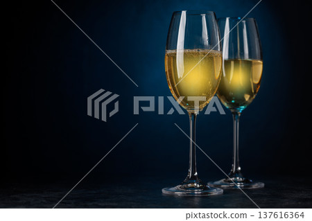 Champagne glasses on dark blue background Champagne glasses on dark blue background 137616364