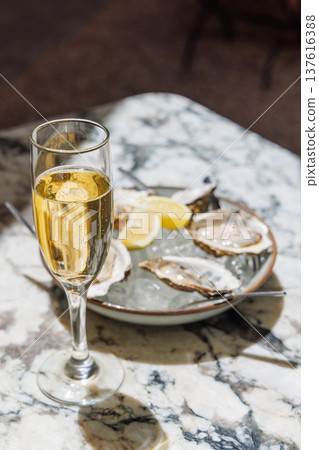 Fresh oysters on ice with champagne in sunlight 137616388