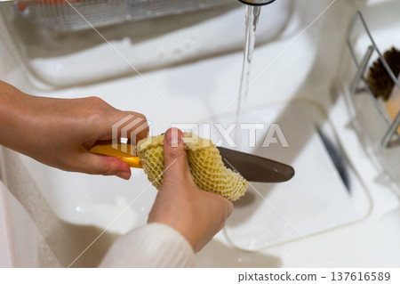 A woman washing a knife A woman washing a knife 137616589