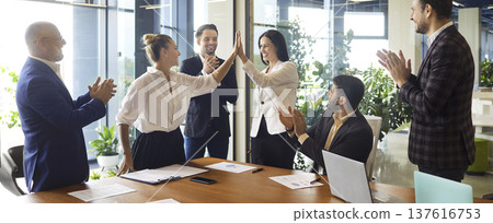 Business team celebrating successful agreement with high five in office meeting Business team celebrating successful agreement with high five in office meeting 137616753