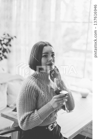 Beautiful young girl sitting at a table in a 137616946