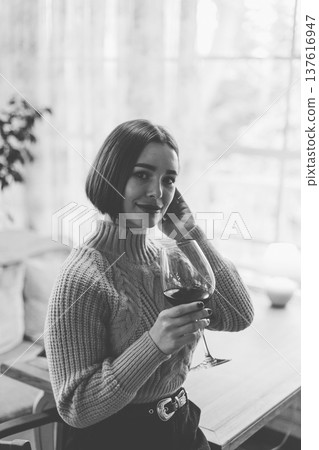 Beautiful young girl sitting at a table in a 137616947