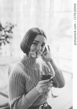Beautiful young girl sitting at a table in a 137616948