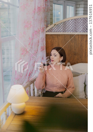 Beautiful young girl sitting at a table in a Beautiful young girl sitting at a table in a 137616951