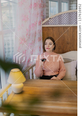Beautiful young girl sitting at a table in a Beautiful young girl sitting at a table in a 137616952