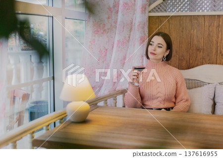 Beautiful young girl sitting at a table in a 137616955