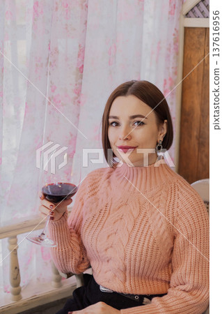 Beautiful young girl sitting at a table in a 137616956