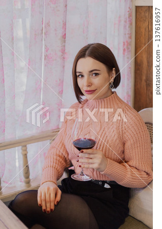 Beautiful young girl sitting at a table in a 137616957